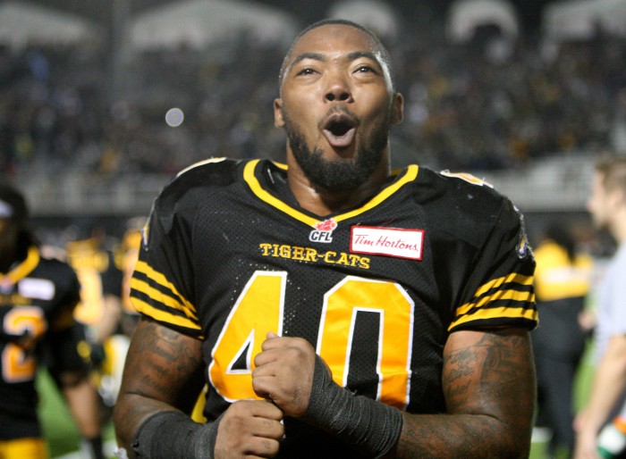 Ti-Cat's Eric Norwood  celebrates on the bench at the end of CFL action between the Toronto Argonauts and the Hamilton Tiger Cats, in Guelph, Monday, October 14, 2013.  Ti-Cat won 24-18 winning the season series.  (CFL PHOTO - Dave Chidley)